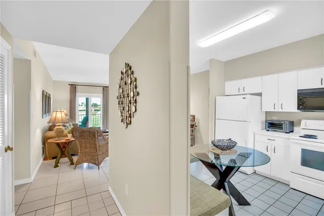 a kitchen with a sink white cabinets and white appliances