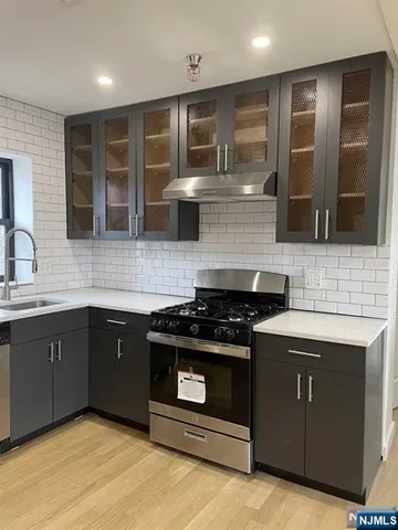 a kitchen with stainless steel appliances granite countertop a stove and a sink