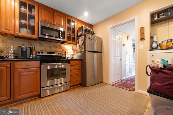 a kitchen with stainless steel appliances granite countertop a refrigerator and a stove top oven
