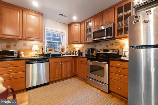a kitchen with stainless steel appliances granite countertop a refrigerator sink and cabinets