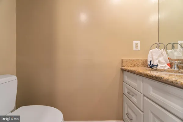 a bathroom with a granite countertop toilet and sink