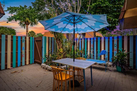 a patio with a table and chairs under an umbrella
