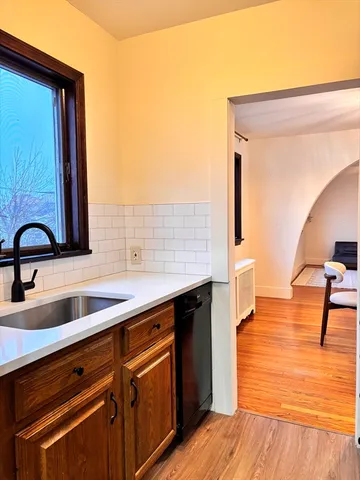 a kitchen with a sink cabinets and wooden floor