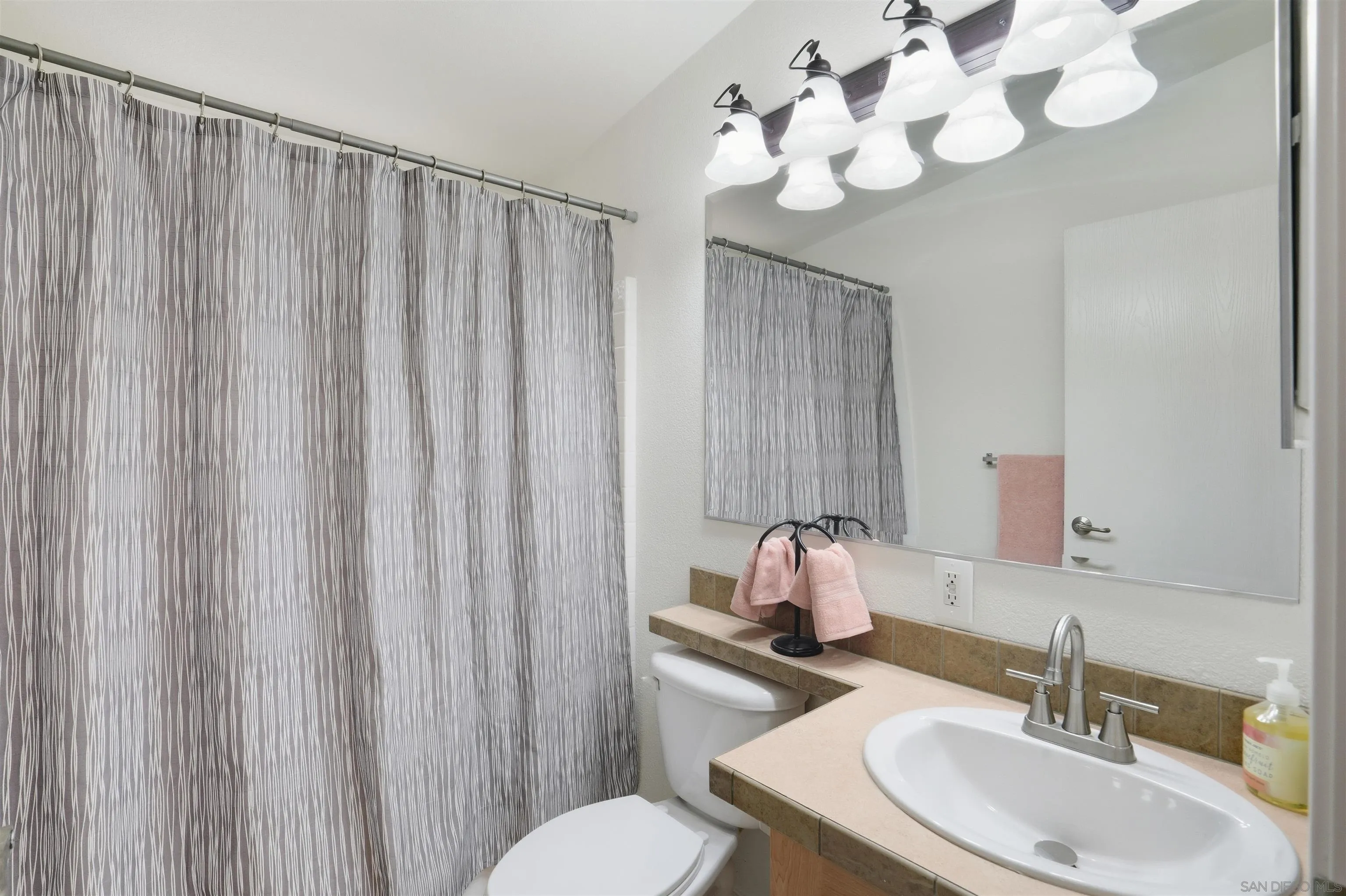 15453 Woods Valley Road Valley Center, CA 92082 - Photo 21 of 38 a bathroom with a sink vanity mirror and toilet