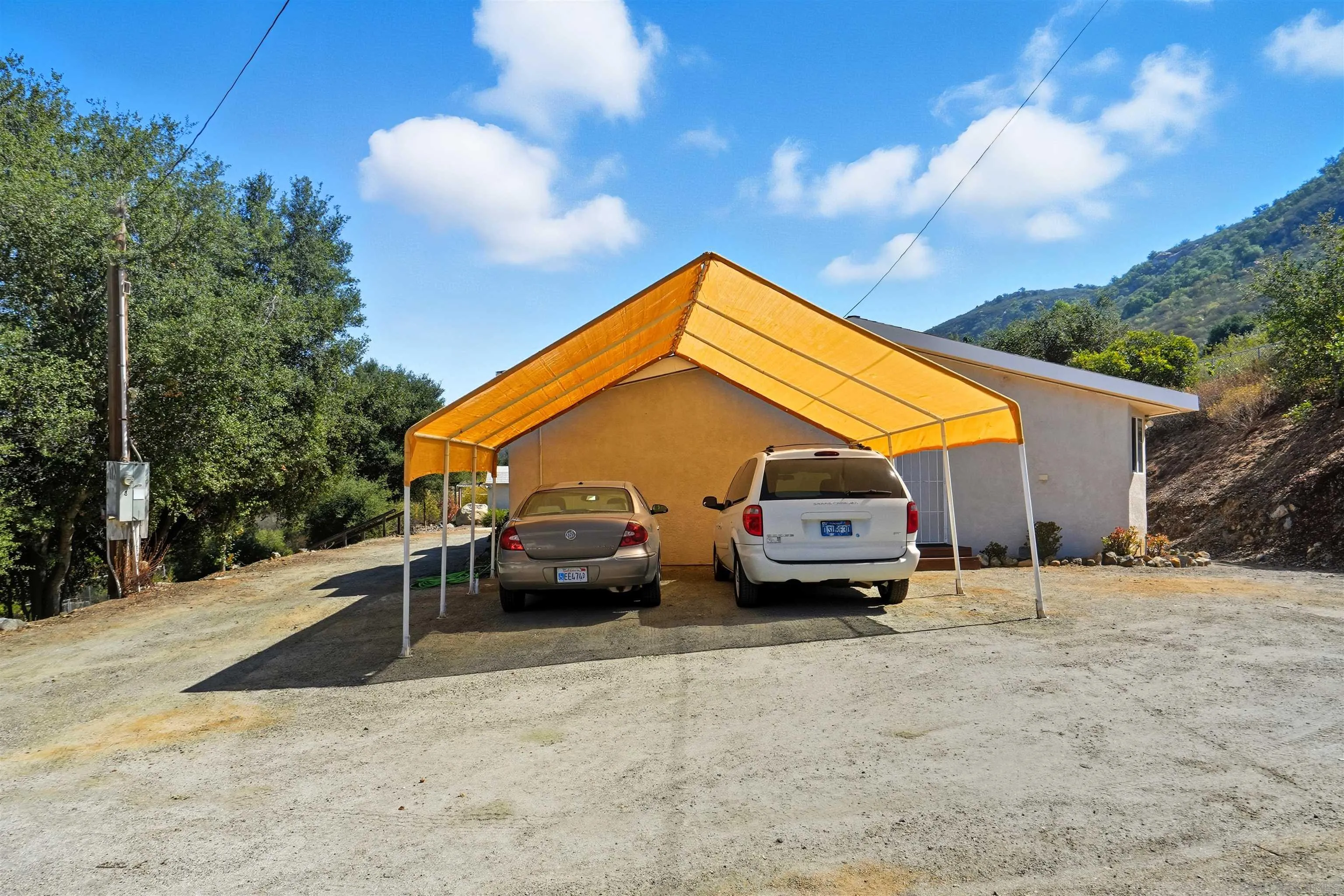 15453 Woods Valley Road Valley Center, CA 92082 - Photo 29 of 38 a car parked in front of white house