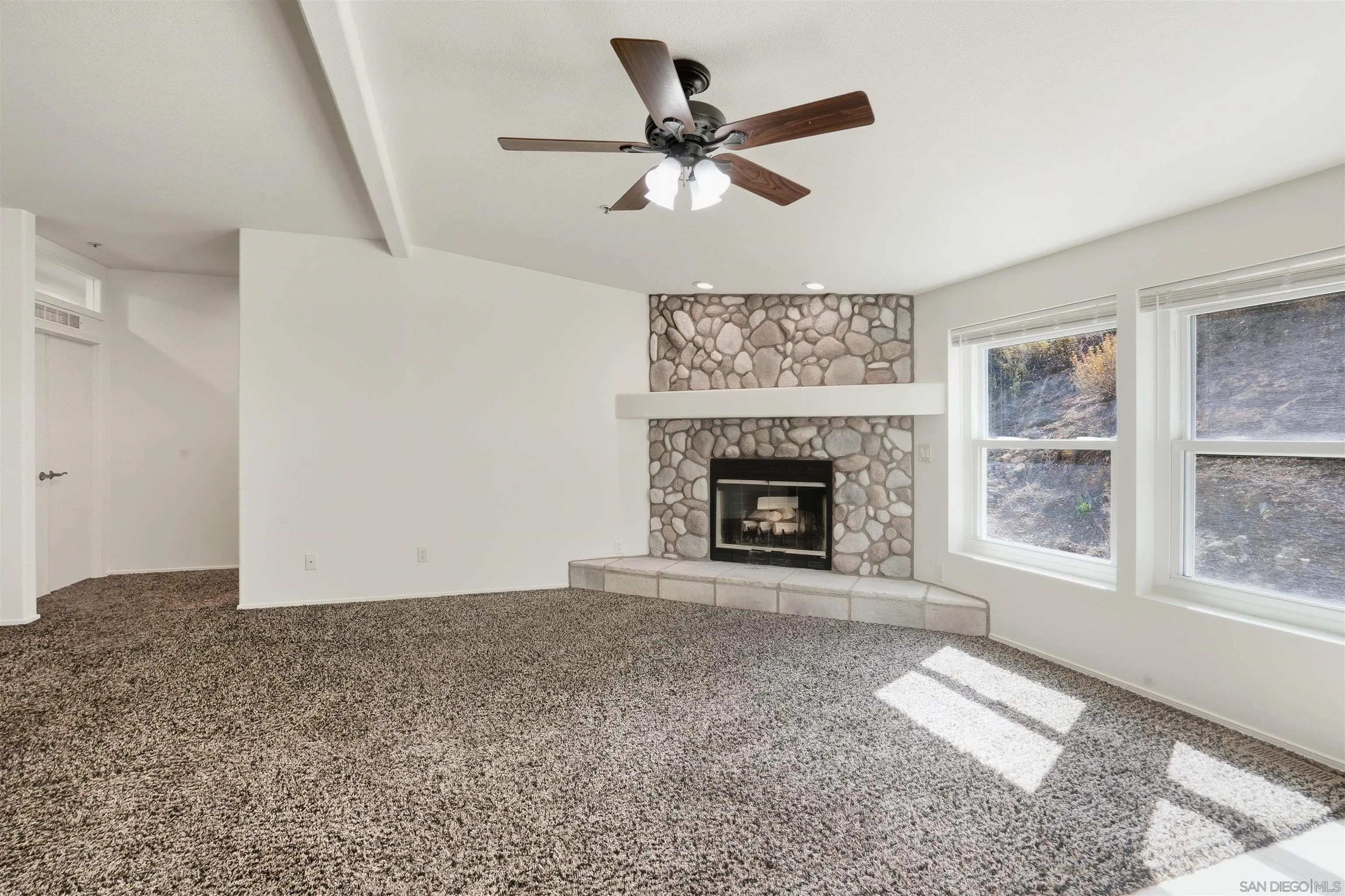 15453 Woods Valley Road Valley Center, CA 92082 - Photo 7 of 38 a view of an empty room with a fireplace and a window
