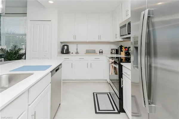 a kitchen with kitchen island a sink stove and refrigerator