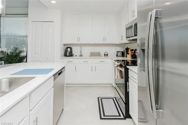 a kitchen with kitchen island a sink stove and refrigerator