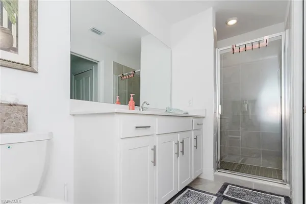 a bathroom with a toilet sink vanity and mirror