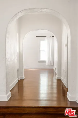 a view of empty room with wooden floor