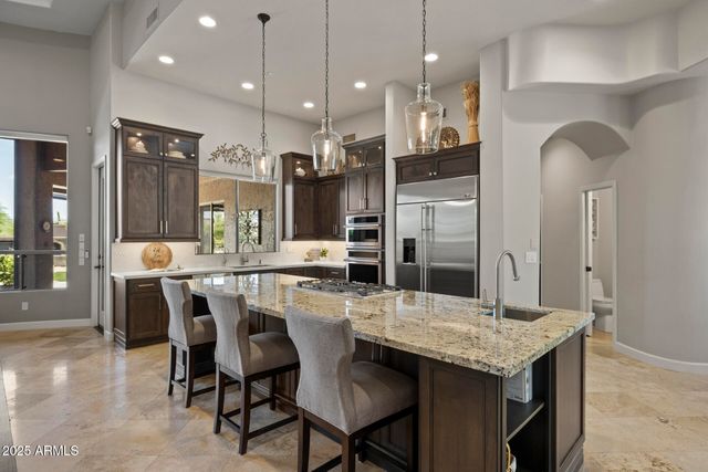 a large kitchen with a counter space a sink stainless steel appliances and cabinets