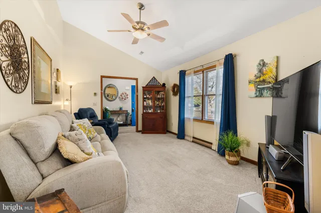a living room with furniture a flat screen tv and a large window