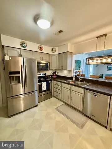 a kitchen with stainless steel appliances granite countertop a refrigerator sink and cabinets