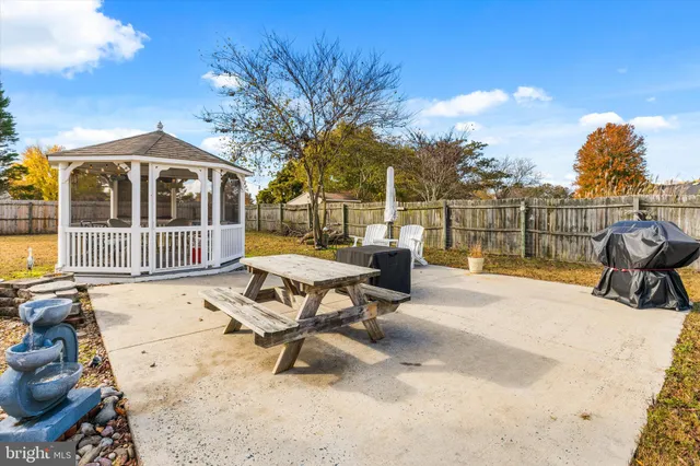 a view of a patio with table and chairs with wooden floor and fence