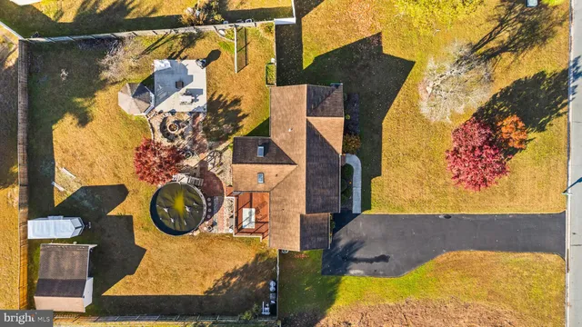 a house that is sitting in the grass with large trees
