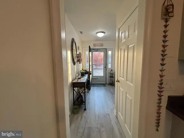 a view of a hallway to a livingroom and a dining room with furniture
