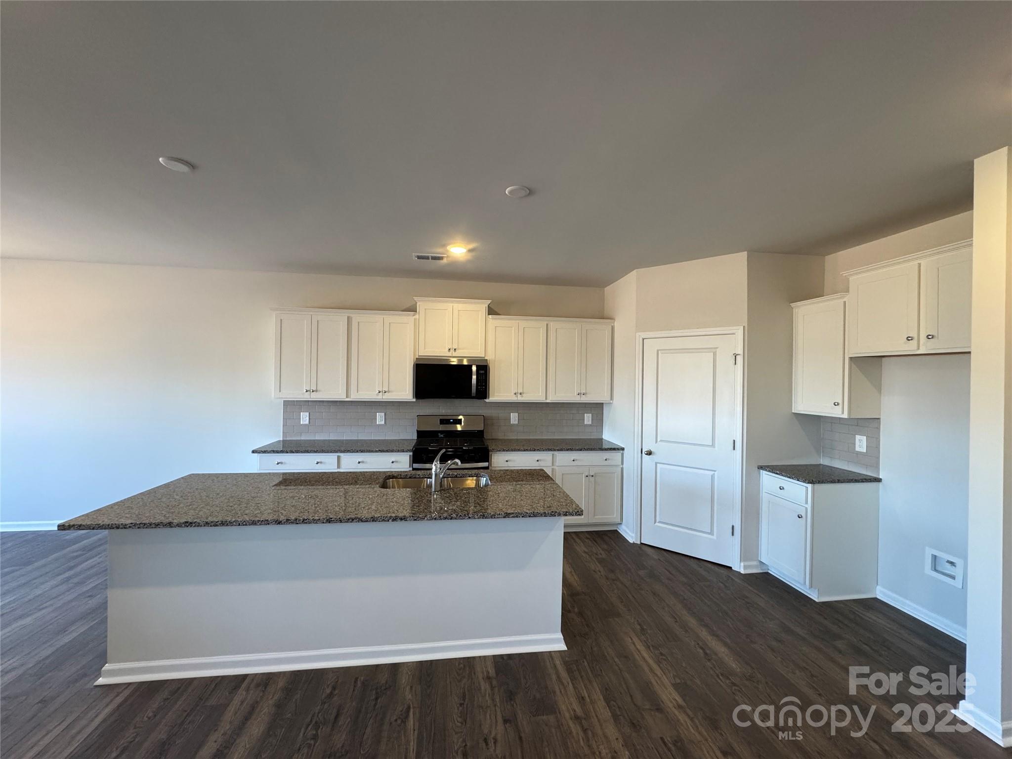 467 Brick House Road Gaffney, SC 29340 - Photo 3 of 17 a kitchen with kitchen island a sink dishwasher a stove and white cabinets with wooden floor