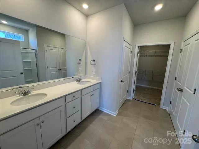 a spacious bathroom with double vanity sink and mirror