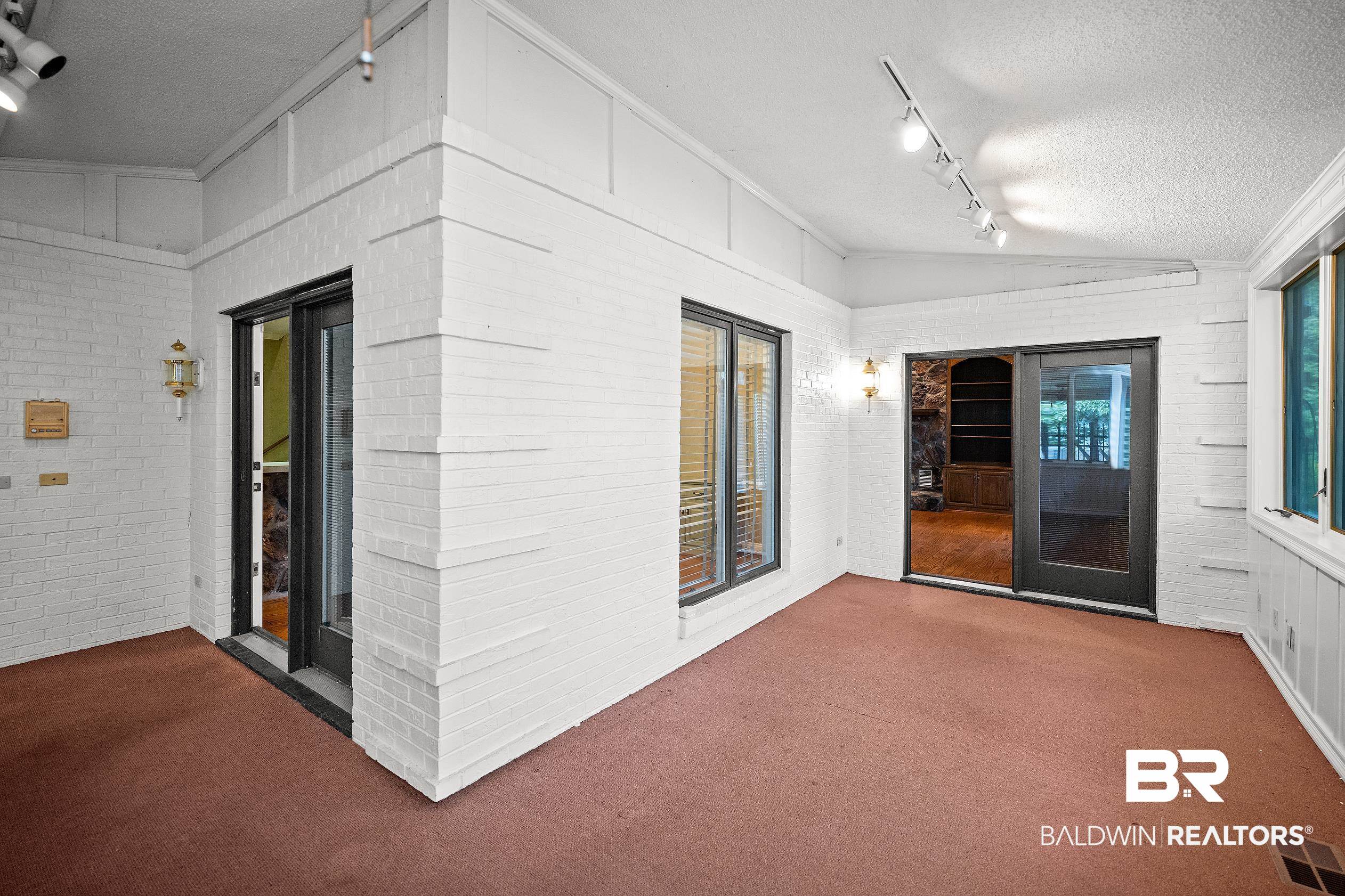 329 Norwood Road Monroeville, AL 36460 - Photo 15 of 49 Sunroom featuring a textured ceiling, painted brick walls, and track lighting