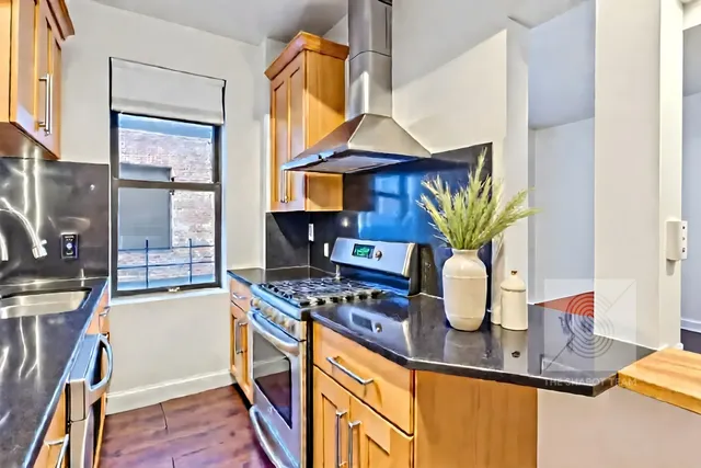 a kitchen with stainless steel appliances a stove and a wooden cabinets