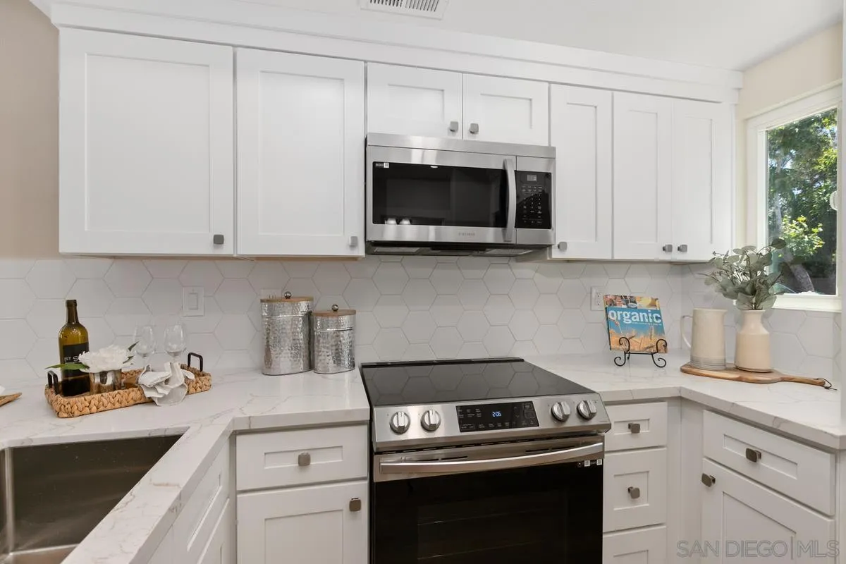 2301 Kings View Circle Spring Valley, CA 91977 - Photo 14 of 26 a kitchen with white cabinets stainless steel appliances and sink