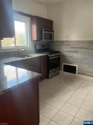 a kitchen with stainless steel appliances a stove a sink and a microwave