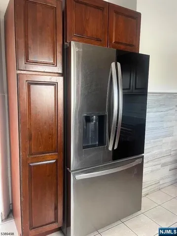 a metallic refrigerator freezer sitting in a kitchen