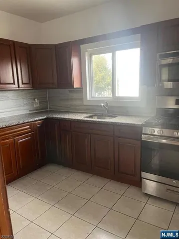 a kitchen with a sink stove top oven and cabinets