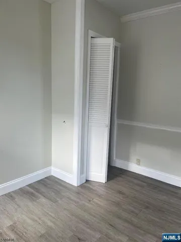 an empty room with wooden floor and closet