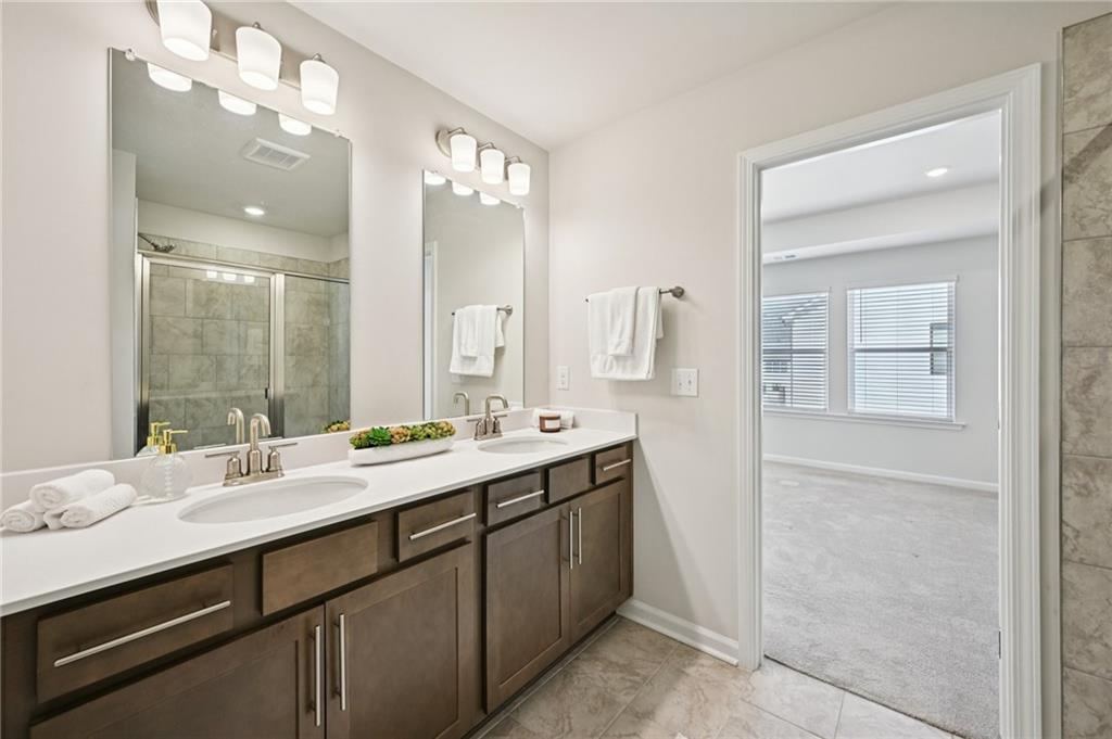216 Wilder Ridge Way Lawrenceville, GA 30044 - Photo 27 of 46 a bathroom with a double vanity sink and mirror