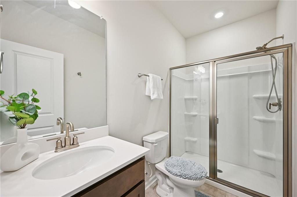 216 Wilder Ridge Way Lawrenceville, GA 30044 - Photo 33 of 46 a bathroom with a granite countertop sink a toilet and shower
