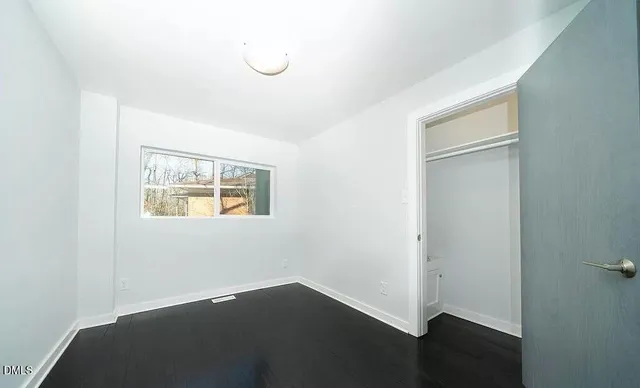 a view of a house with a large window and wooden fence