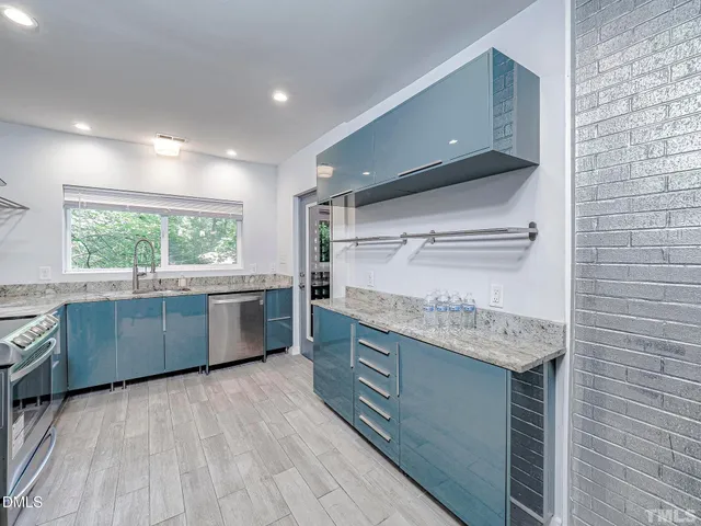 a kitchen with stainless steel appliances granite countertop a sink and window