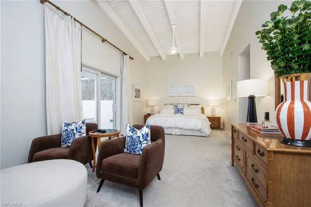 a bedroom with furniture a flat screen tv and a potted plant