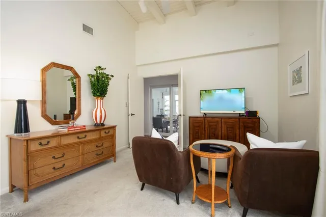 a living room with furniture a flat screen tv and a mirror