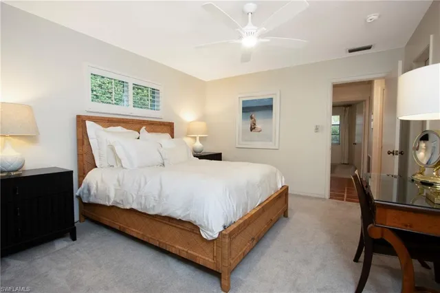 a bedroom with a bed a table and chair