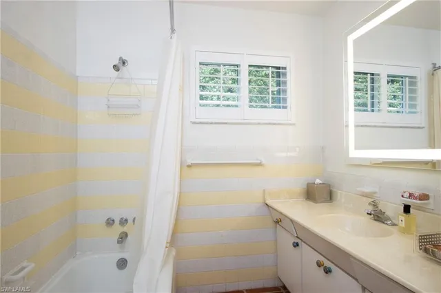 a bathroom with a granite countertop sink a shower and a bathtub