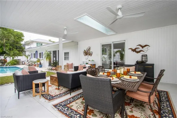 a dining room with furniture a table and a potted plant