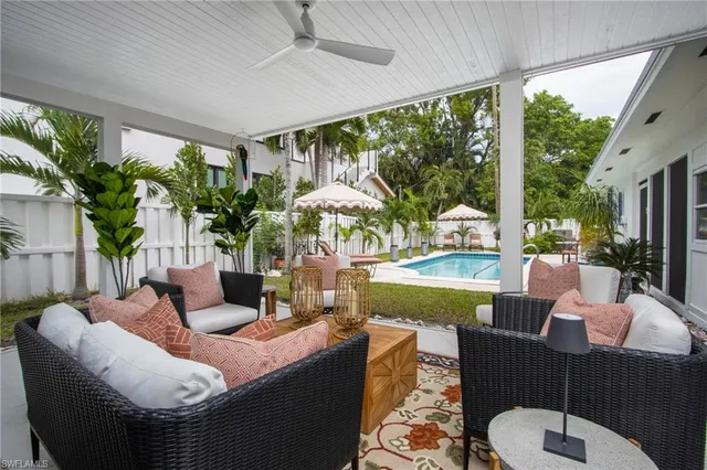 a living room with patio furniture and a potted plant