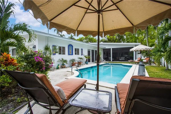 a view of a patio with table and chairs under an umbrella