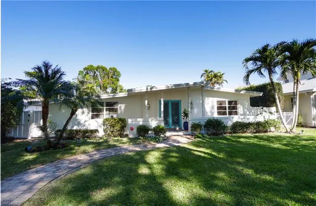a front view of a house with a garden and yard
