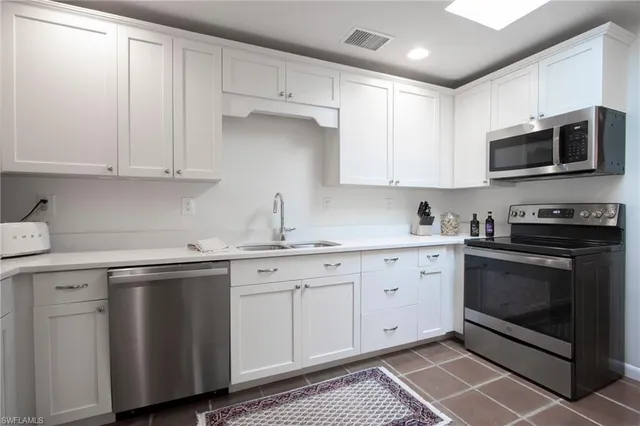 a kitchen with stainless steel appliances granite countertop a sink and a stove