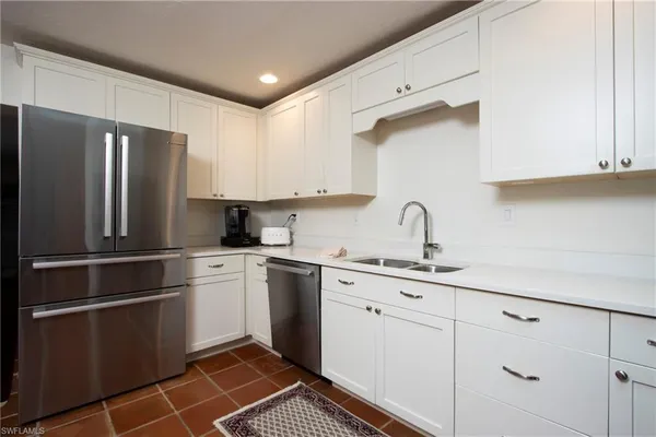 a kitchen with a refrigerator sink and cabinets