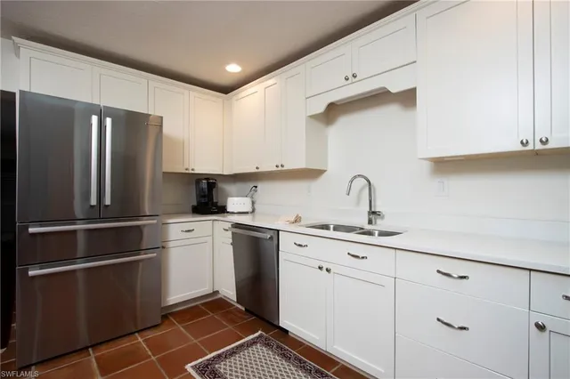 a kitchen with a refrigerator sink and cabinets