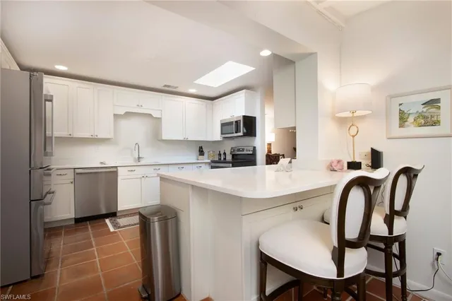 a kitchen with a table chairs sink and cabinets