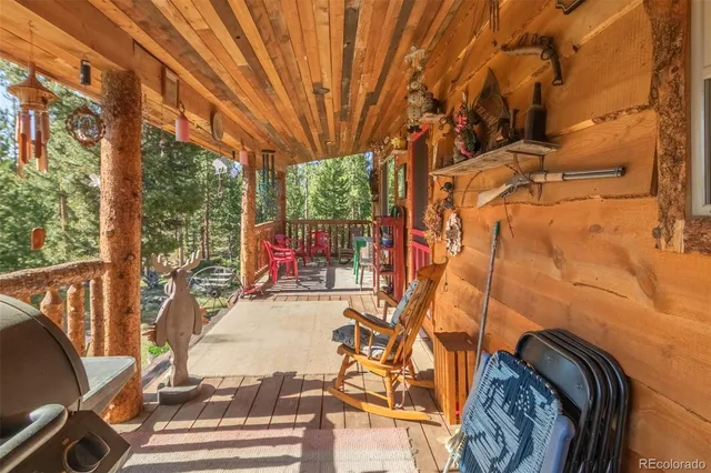 a view of house with a deck and a yard