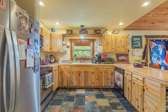 a kitchen with stainless steel appliances a sink and a refrigerator