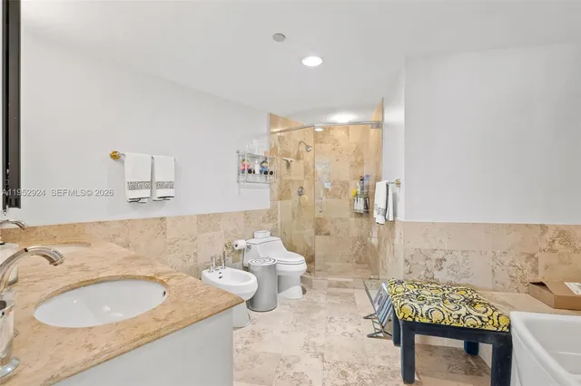 a bathroom with a granite countertop sink a toilet and a shower
