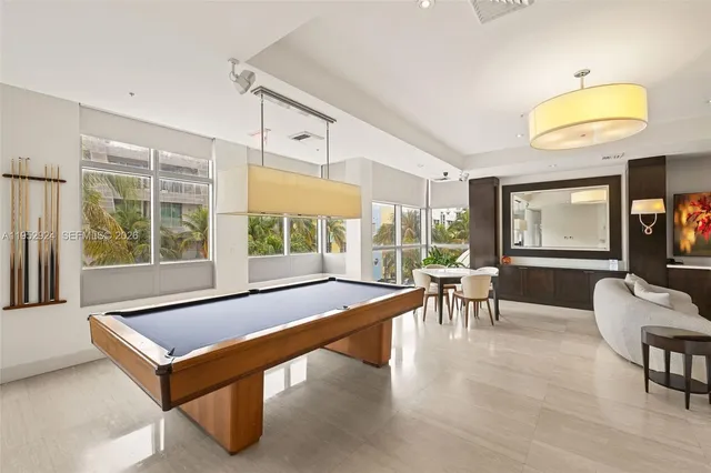 a living room with furniture pool table and a large window