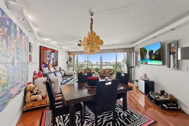 a view of a dining room with furniture a rug and wooden floor